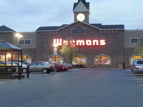 a building with cars parked in front of it at dusk, lit up by lights