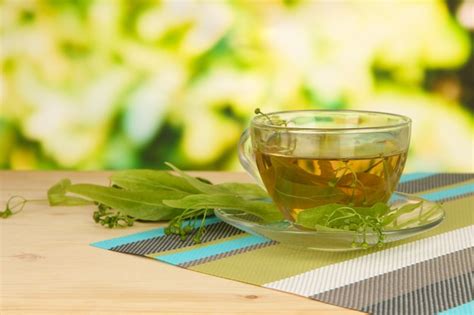 Premium Photo Glass Cup Of Tea With Linden On Napkin On Wooden Table