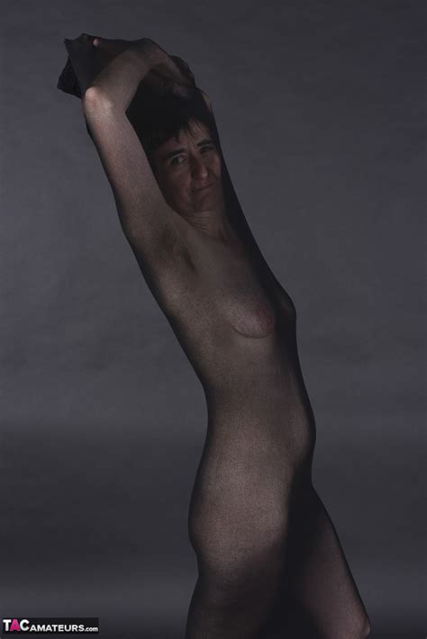 Naked Mature Woman Encases Herself In A Stocking Atop A Rug Pichunter