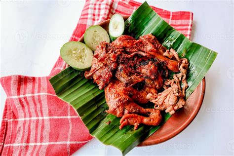 grilled chicken or ayam bakar with cucumber slash served on banana leaf ...