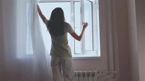 Woman opening curtains and closing windo... | Stock Video | Pond5