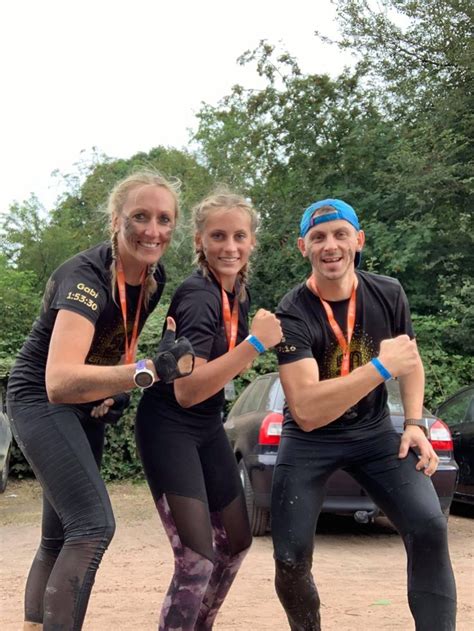 Three People In Wetsuits Posing For The Camera