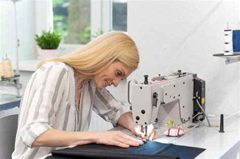 Blonde Cute Female Designer Sitting Sewing Machine Looking Involved