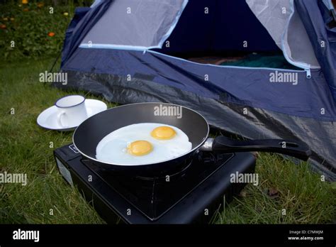 Cooking Two Fried Eggs On A Small Portable Gas Camping Stove In Front Of The Open Door Of A Dome