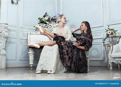 Joven Y Bonita Bailarina De Ballet De Brunette En El Piano Con Mujer Rubia En El Lujoso Estilo