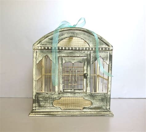 A Birdcage With A Blue Ribbon Tied Around It