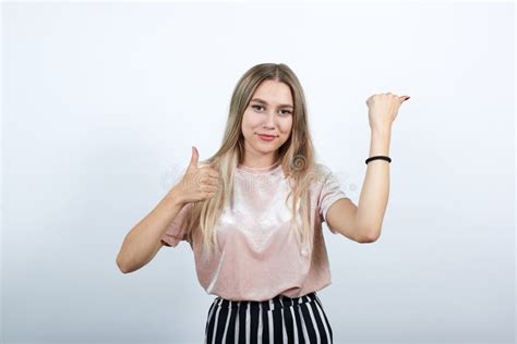 Mulher Caucasiana Atrativa Apontando Para O Lado Mantendo O Polegar