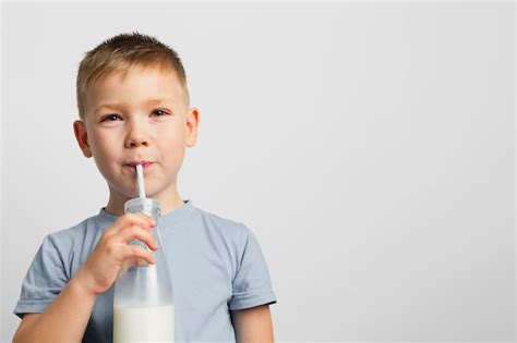 Garçon Buvant Du Lait Avec De La Paille Photo Gratuite