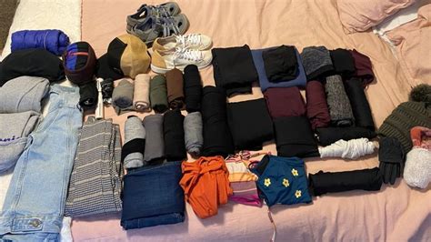 An Assortment Of Clothes Laid Out On A Bed