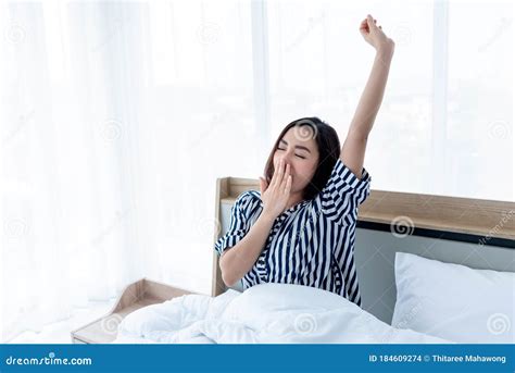 Pretty Asian Woman Sitting On A Clean White Bed She Covered Her Mouth