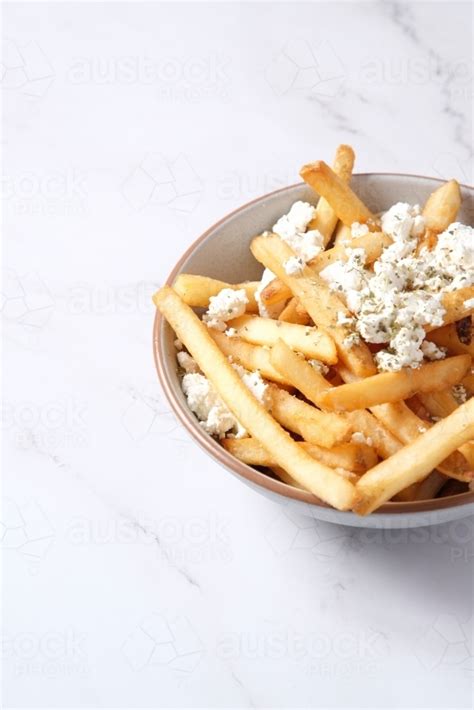 Image of Bowl of hot chips with sprinkled feta cheese - Austockphoto