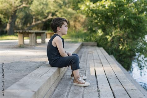 Alone Boy sitting on the pier Stock Photo | Adobe Stock