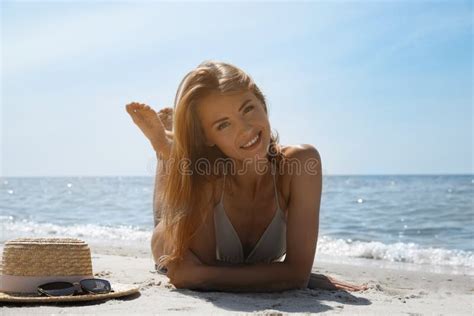 Attractive Woman In Bikini Lying On Sandy Beach Near Sea Stock Photo