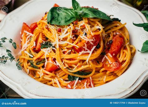 Spaghetti Pasta With Tomato Sauce Parmesan And Basil On A White Plate