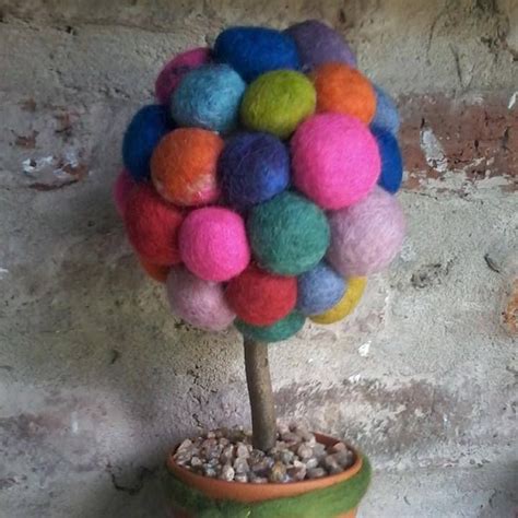 A Small Potted Plant With Colorful Balls On It S Top And Gravel Below