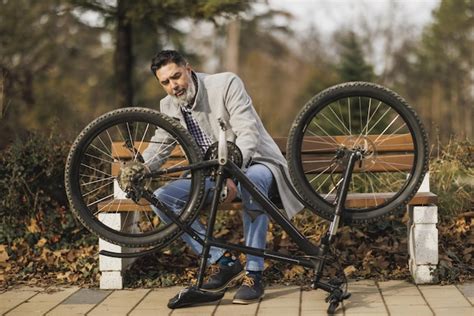 Premium Photo | Businessman Fixes Bicycle Chain in Park During Break