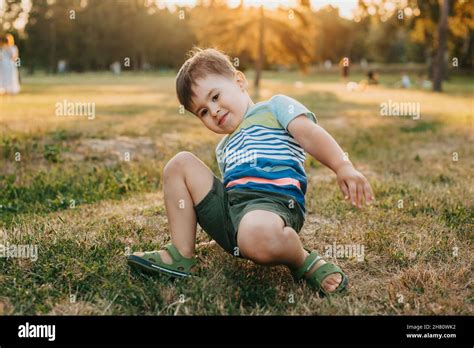 Portrait of a boy trying to get up after falling down in the park