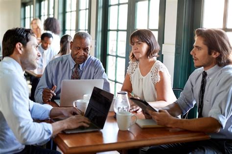 Premium Photo Business Team Having Informal Meeting Around Table In