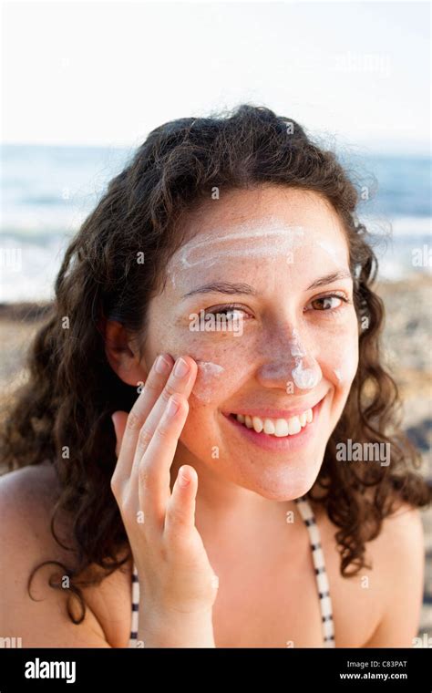 Smiling Woman Applying Sunscreen To Face Stock Photo Alamy