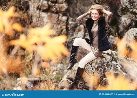 Beautiful Young Woman Sitting On The Rocks In Autumn Travel Stock