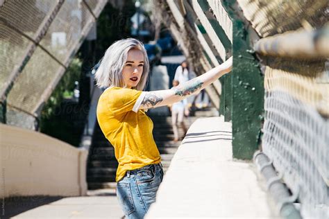 Portrait Of Urban Young Female In City Next To Chain Link Fence By Stocksy Contributor Jesse