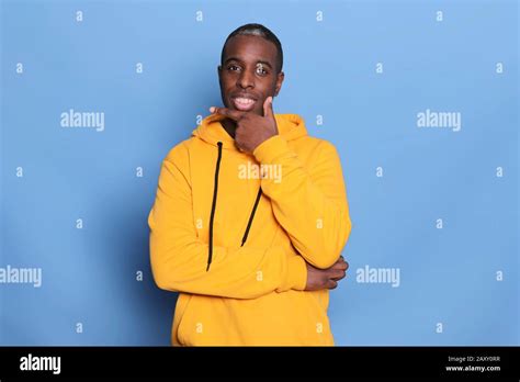 Studio Shot Of Serious Black Man Keeps Hand Under Chin Wearing Casual