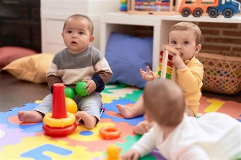 Grupo de niños pequeños jugando con juguetes sentados en el suelo en el