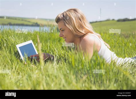 Pretty Blonde Lying On Grass Using Her Tablet Stock Photo Alamy