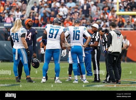 Referee Shawn Smith (14) talks with Detroit Lions quarterback Jared ...