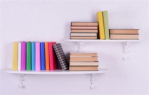 Premium Photo | Books on shelves on white wall background