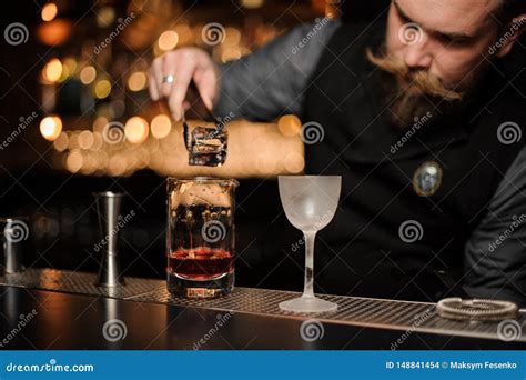 Bartender Putting An Ice Cube To The Measuring Glass Cup Stock Photo