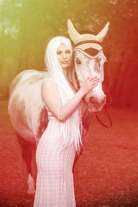 Une Femme Blonde Sexy Et Sexy Du Caucase Avec De Longs Cheveux Blancs Debout Avec Un Cheval