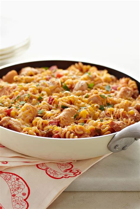 A Casserole Dish With Meat And Vegetables In It On A White Tablecloth