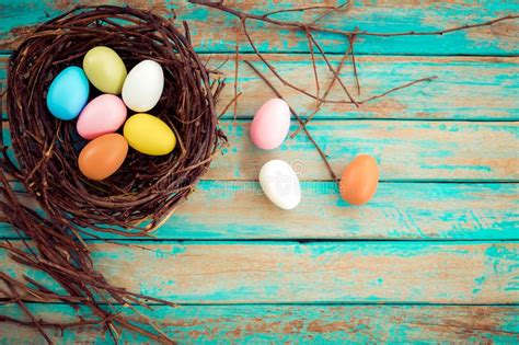 Colorful Easter Eggs In Nest With Flower On Rustic Wooden Planks