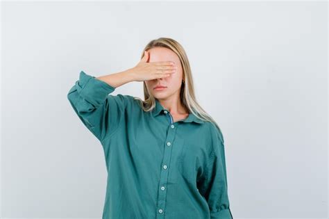 Fille Blonde Couvrant Les Yeux Avec La Main En Blouse Verte Et à La