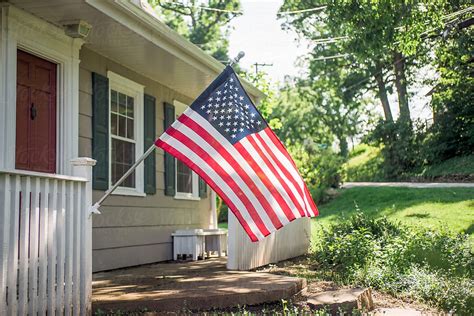 American Flag Displayed On The Porch Of A Residential Home By