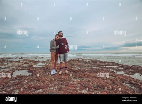 Jeune couple gay debout côte à côte sur la plage Photo Stock Alamy