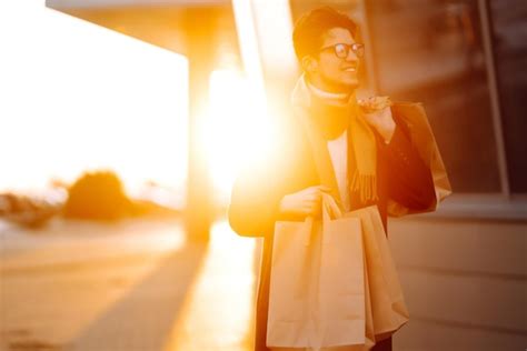 Homem elegante pacotes de papel depois de fazer compras ao pôr do