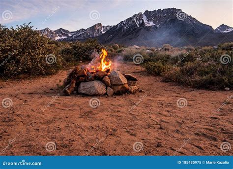 Campfire Flames In Rock Fire Pit In Desert At Base Of Mountains Stock