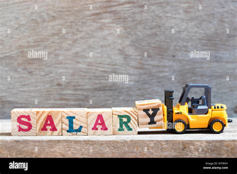 Toy Forklift Hold Letter Block Y To Complete Word Salary On Wood