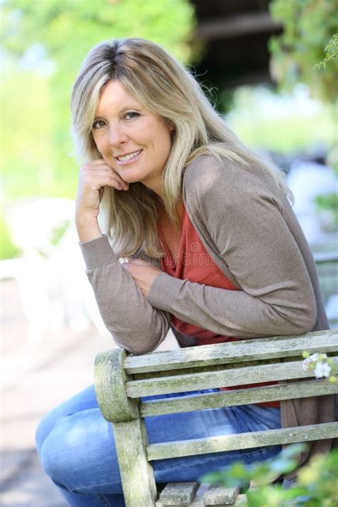Reife Blonde Frau Im Garten Sitzt Stockfoto Bild von glücklich mittlere 64656614