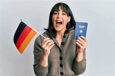 Young Hispanic Woman Holding Germany Flag And Passport Celebrating