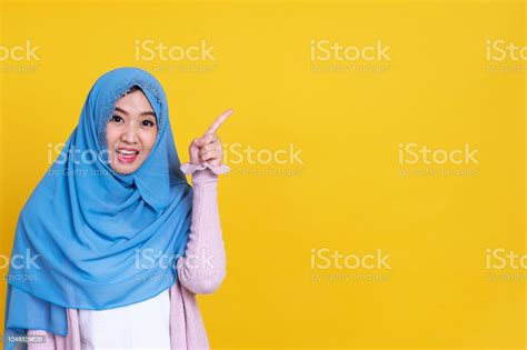 Happy Muslim Woman In Hijab Pointing At Something Isolated On Color