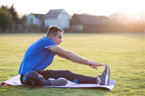 Premium Photo Young Sportive Man Doing Stretching Exercises Before