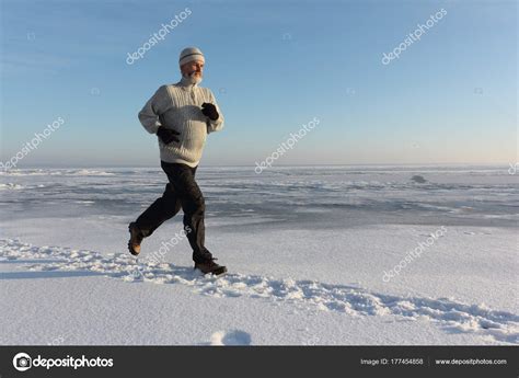 Mature Man Running Across The Ice Of A Frozen River Stock Photo Nataliia Makarova 177454858