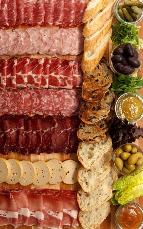 Charcuterie Board Cured Meats And Pâtés Accompanied By Pickles Olives And Chilli Jams