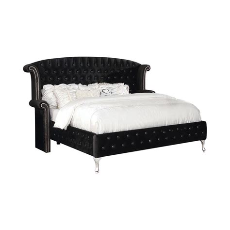 A Black Bed With White Sheets And Pillows