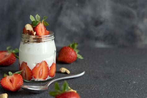 Nueces De Yogur Griego Y Fresas En Un Frasco De Vidrio Sobre Una Mesa