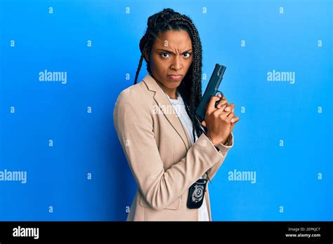 African American Police Woman Holding Gun Skeptic And Nervous Frowning