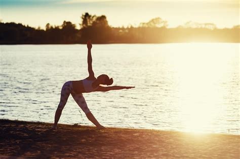 Silueta De Una Mujer Joven Haciendo Ejercicios De Yoga En La Playa Del